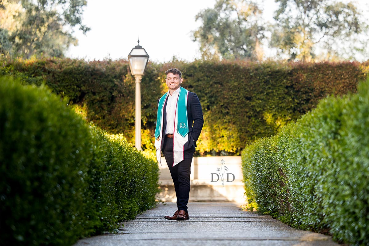 Graduation photo with green hedges